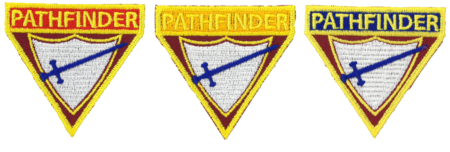 Dreieckige Abzeichen, Aufschrift Pfadfinder, mit jeweils einer Farbe für Jungpfadfinder, Pfadfinder, Scouts. Grundfarbe des Abzeichens ist rot, im unteren Teil sind ein weißes Schild und ein blaues Schwert abgebildet. 